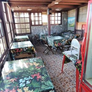 a room with tables and chairs in a building at Pousada Viva Mar in Saquarema