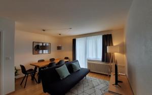 a living room with a couch and a dining room table at Apartment Via Surpunt - Anda in St. Moritz