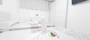 una camera da letto bianca con decorazioni rosa sul letto di Luxury Playa Honda, Ocean View Wifi Free a Playa de las Americas Altre 17 foto