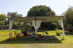 un pabellón con sillas y mesas en un patio en Miss Magi cahuita rooms, en Cahuita