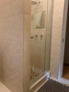 a shower stall with a glass door with a shower at Majestic View Self Catering Guest House in Sabie