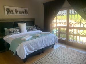 a bedroom with a bed with two towels on it at Majestic View Self Catering Guest House in Sabie