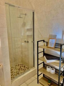 a shower with a glass door in a bathroom at Majestic View Self Catering Guest House in Sabie
