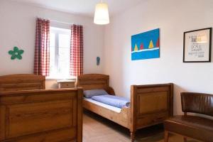 1 dormitorio con 1 cama con muebles de madera y ventana en Ahrentschildt's Ferienwohnung im Reetdachhaus, 