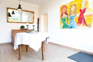 un comedor con una mesa y una pintura en la pared en Ahrentschildt's Ferienwohnung im Reetdachhaus, 