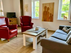 Ahrentschildt's Ferienwohnung im Reetdachhaus : غرفة معيشة مع كرسيين وطاولة قهوة