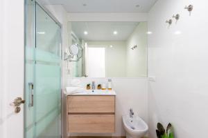 a white bathroom with a sink and a shower at Genteel Home Victoria in Cádiz