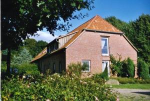 een stenen huis met een raam en een dak bij Ferienwohnung Zum Schwalbennest in Eimke