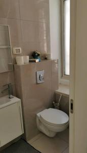 a white bathroom with a toilet and a window at Beautiful apartment in the center ofJerusalem 4 in Jerusalem