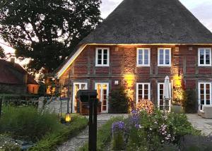 una gran casa de ladrillo con techo de paja en Ahrentschildt's Ferienwohnung im Reetdachhaus, 