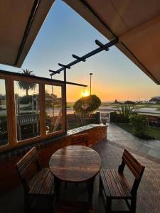 um pátio com uma mesa e cadeiras e vista para o oceano em Seaview Family Cottage em Swakopmund