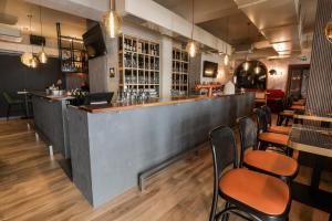 a bar in a restaurant with wooden tables and chairs at Sobe Merlon in Osijek