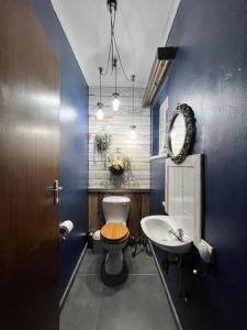 a blue bathroom with a toilet and a sink at Seaview Family Cottage in Swakopmund