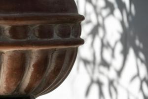 a close up of a wooden object with a shadow on a wall at Edem Luxury Apartments in Nea Peramos