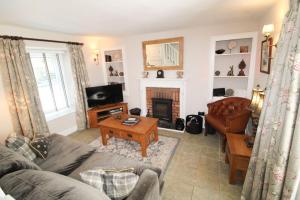 salon z kanapą i kominkiem w obiekcie Kirkstone Cottage ideal for a romantic break centrally located in Ambleside w mieście Ambleside