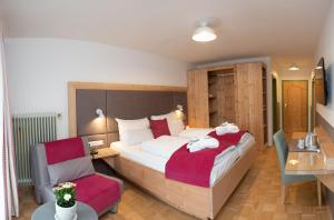 a bedroom with a large bed and a chair at Santner, Hotel in Eugendorf