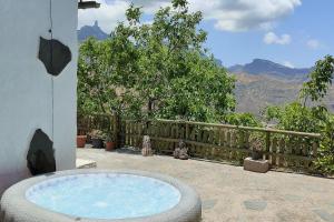 a hot tub on a patio with a view of the mountains at La Cabañita in Las Palmas de Gran Canaria