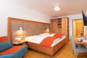 a bedroom with a bed and a desk and a chair at Santner, Hotel in Eugendorf