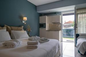 a bedroom with a white bed with towels on it at Edem Luxury Apartments in Nea Peramos