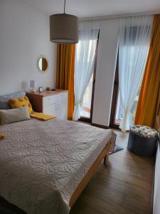 um quarto com uma cama grande e janelas grandes em Divčibare_sunrise em Divčibare