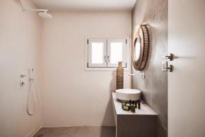 bagno bianco con lavandino e specchio di Serenity Suite Milos a Mandrakia Altre 18 foto