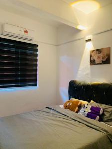 - une chambre avec un lit avec un animal rembourré dans l'établissement Homestay Dizaherbs KT, à Kuala Terengganu