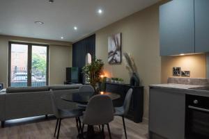 Una cocina y una sala de estar con mesa y sillas. en M1 Townhouse - Free Parking & Central Manchester, en Mánchester