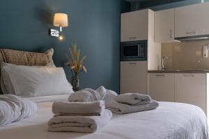 a room with two beds with towels on it at Edem Luxury Apartments in Nea Peramos