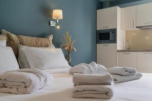 ネア・ペラモスにあるEdem Luxury Apartmentsのベッド1台(タオル付)が備わります。