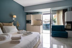 a bedroom with a bed with towels on it at Edem Luxury Apartments in Nea Peramos
