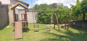 a playground with a swing set in a yard at Pousada Viva Mar in Saquarema