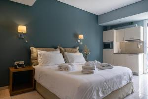 a bedroom with a bed with towels on it at Edem Luxury Apartments in Nea Peramos