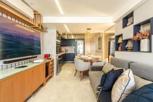 a living room and kitchen with a couch and a table at DELUX PRAIA Flats in Natal