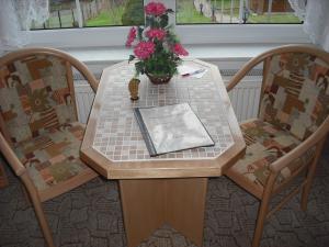 einen Tisch mit einer Blumenvase drauf in der Unterkunft Pension Möhring in Bad Suderode