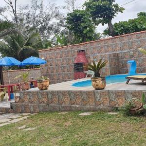 a patio with a brick wall and a swimming pool at Pousada Viva Mar in Saquarema
