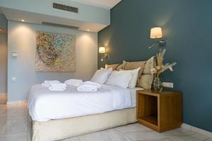 a bedroom with a white bed with towels on it at Edem Luxury Apartments in Nea Peramos