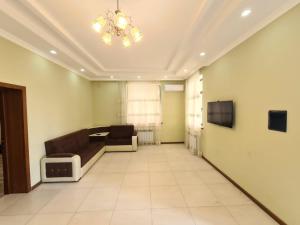 a living room with a couch and a television at Villa Qebele in Küsnǝt