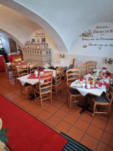 ein Restaurant mit Tischen und Stühlen in einem Zimmer in der Unterkunft Pension Benedikt in Aschau am Inn