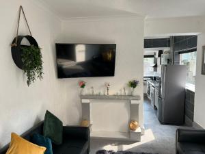 a living room with a couch and a tv on a wall at 4 Bed House! 10%OFF! Groups, Contractors! 9 Guests - Garden - Free On street Parking in Cardiff