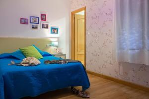 1 dormitorio con 1 cama con edredón azul en Balenax Pensión, en Gijón
