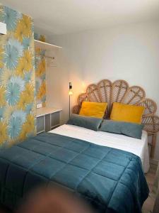 a bedroom with a large bed with a blue blanket at Mon Appart à la plage, piscine, wifi, tv + Netflix in Frontignan