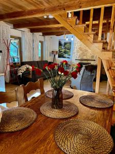 a wooden table with a vase of flowers on it at Domek Serce Lasu in Hutki