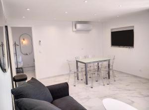 ジュアン・レ・パンにあるRésidence Graziella Appartement 99のテーブルと椅子とテレビのあるリビングルーム