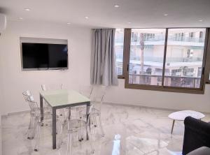 ジュアン・レ・パンにあるRésidence Graziella Appartement 99のテーブルと椅子とテレビのあるダイニングルーム