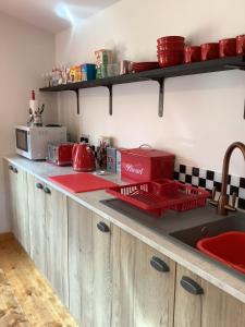 a kitchen counter with red dishes on the counter top at Oak ridge cabin in Norwich