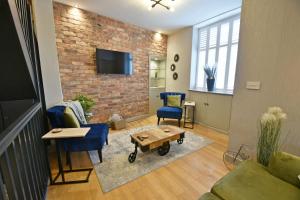 a living room with blue chairs and a brick wall at Quirky cottage set in Clitheroe in Clitheroe