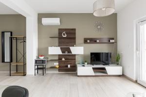een woonkamer met witte meubels en een televisie bij Apartments Villa Salona Sky in Solin