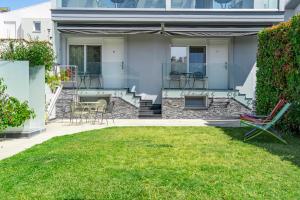 a patio with chairs and tables on a house at Edem Luxury Apartments in Nea Peramos