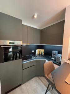 a kitchen with gray cabinets and a table and a dining room at Ferienwohnung Gorch-Fock Scharbeutz in Scharbeutz