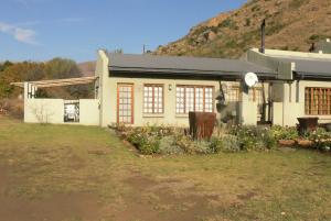 a house with a clock on the side of it at Aspen Guest House in Clarens